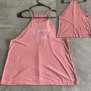 Club Pilates, “Movement Heals” in pink/yellow writing, logo on back